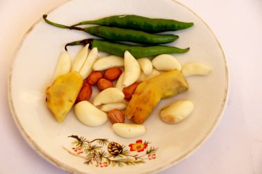 Hindistan çiğ baharatlı biber, sarımsak, zencefil ve beyaz tabakta yer fıstığı.
