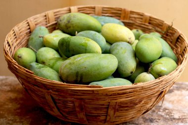 Geleneksel sepetin içinde bir sürü çiğ mango.