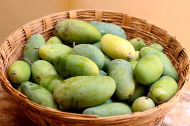 Geleneksel sepetin içinde bir sürü çiğ mango.