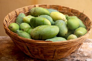Geleneksel sepetin içinde bir sürü çiğ mango.