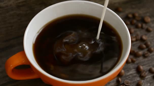 Milch in eine Tasse Kaffee gießen — Stockvideo