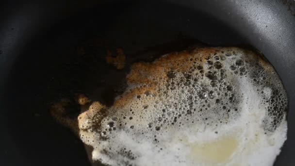 Куб сливочного масла плавления шипящий коричневый в сковороде антипригарный в замедленной съемке — стоковое видео