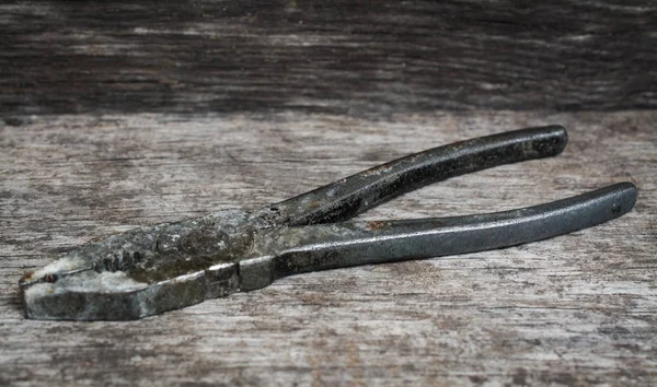 Old pliers on the wooden table — Stock Photo, Image