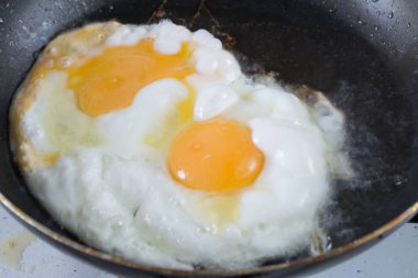 İki kızarmış yumurta bir tavada, kahvaltıda kızarmış yumurta kadar güneşli tarafı. Sağlıklı gıda Özet.