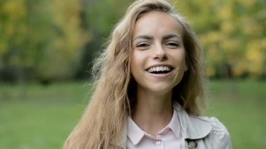 güzel genç kız kamera ve mutlu gülümsüyor görünüyor