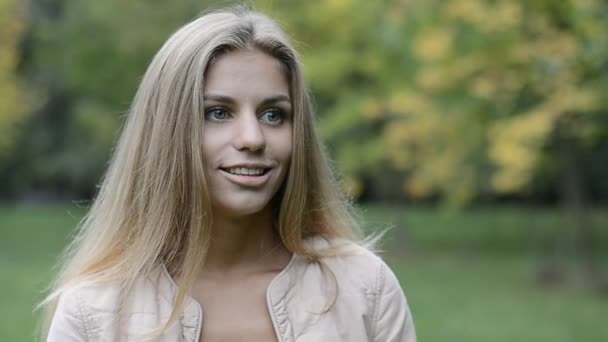 Szép, fiatal lány a parkban beszél — Stock videók