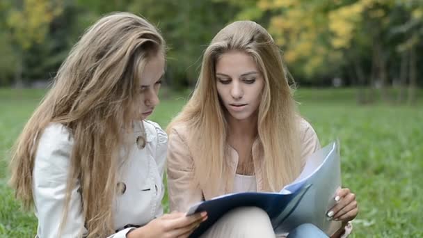 Dos hermosas estudiantes femeninas haciendo la tarea — Vídeo de stock