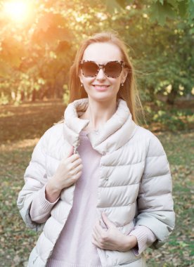 bir parkta sonbaharda gülümseyen güzel kadın