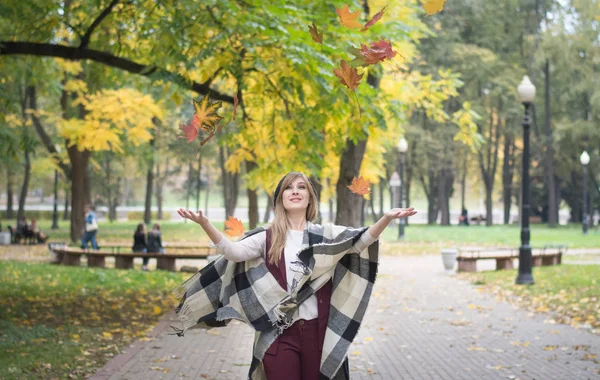 Femme jetant des feuilles d'automne sur le parc — Photo