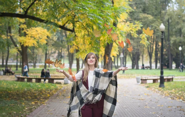 Mulher feliz jogando folhas — Fotografia de Stock