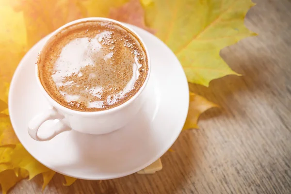 Hojas de otoño y taza de café sobre fondo de madera — Foto de Stock