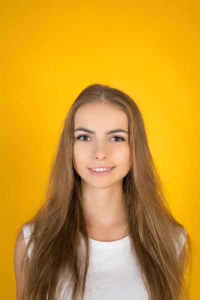幸せな陽気な若い女はうれしそうな 魅力的な笑顔でカメラ目線します スタジオ撮影黄色空白のスタジオの壁に分離 — ストック写真
