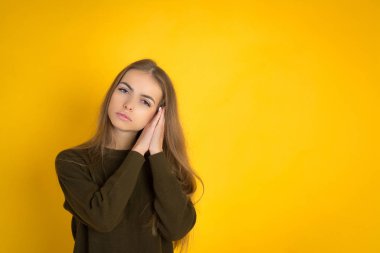 Sarı arka plan yatıya izole poz güzel genç Sevimli kadın fotoğrafı.