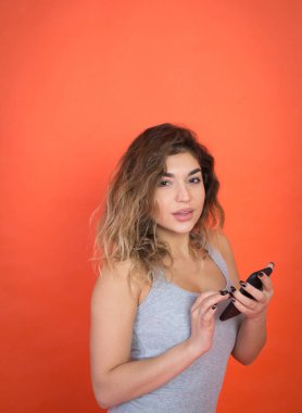 Güzel bir genç kadın kamera cep telefonu kullanırken seyir stüdyo çekim