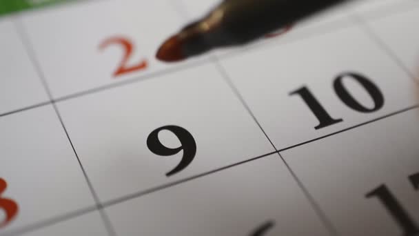 Подписание дня в календаре красной ручкой девять — стоковое видео