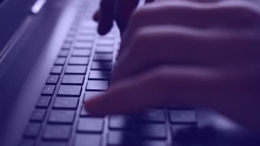 Bir dizüstü bilgisayarda yazarak parmak, mavi tonda