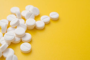 aspirin pills on yellow background close up photo