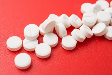 Yığın ağrı kesici hapları üzerinde kırmızı backgroind izole