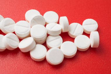 Yığın ağrı kesici hapları üzerinde kırmızı backgroind izole