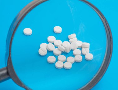 Sağlık kavramı, beyaz hap mavi bir arka plan üzerinde izole