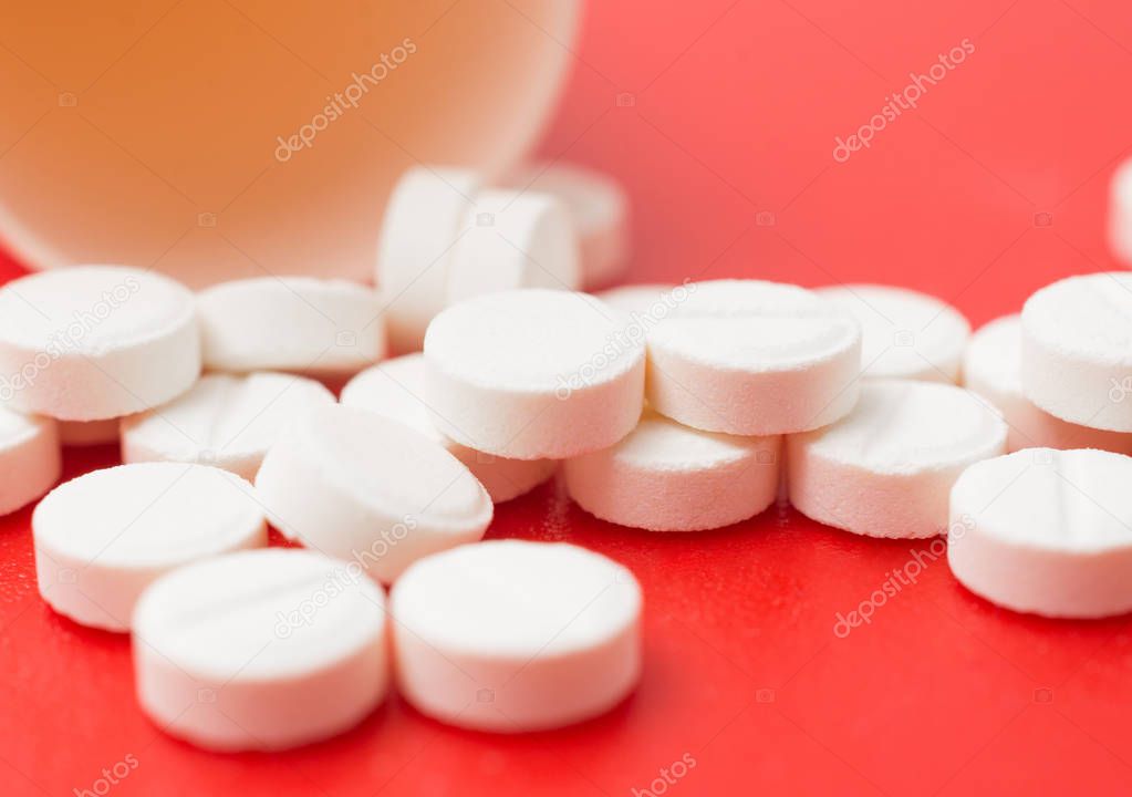 painkiller pills close up on red background
