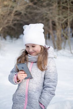 güzel küçük kız parkta bir cep telefonu tutan