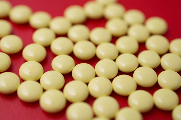 Жовті заспокійливі таблетки ізольовані на червоному тлі — стокове фото