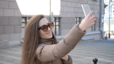 Trendy kadın bloglama ve modern şehir bahar veya sonbahar selfie yapıyor