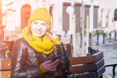 Güzel genç kız bir şehir sokakta onu Smartphone SMS yazıyor