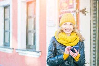 Onu akıllı telefonda çok çekici kadın SMS, gülümsüyor ve kamera içine bakıyor