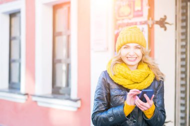 Onu akıllı telefonda çok çekici kadın SMS, gülümsüyor ve kamera içine bakıyor