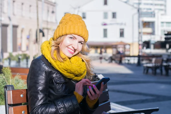 Красивая молодая девушка пишет смс на смартфоне на городской улице — стоковое фото