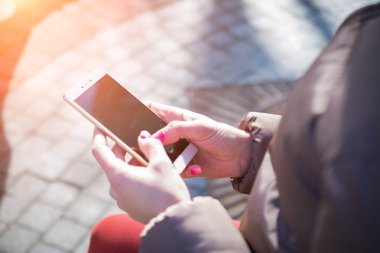 sokakta akıllı telefon kullanan kadın