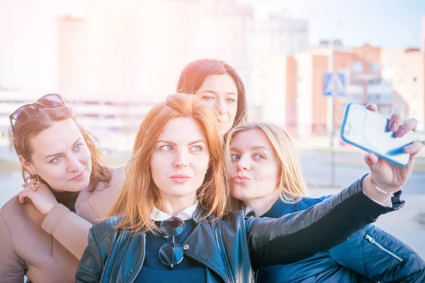 Four young very attractive women take selfies on urban streets — Stock Photo, Image