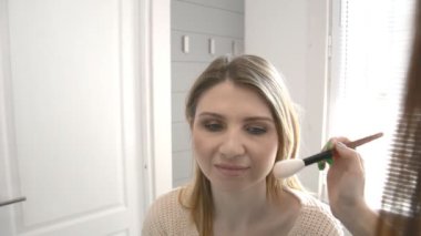 Göz gölgesi ile sarışın makyaj kadın ve fırça resme makyaj. Güzellik konsepti