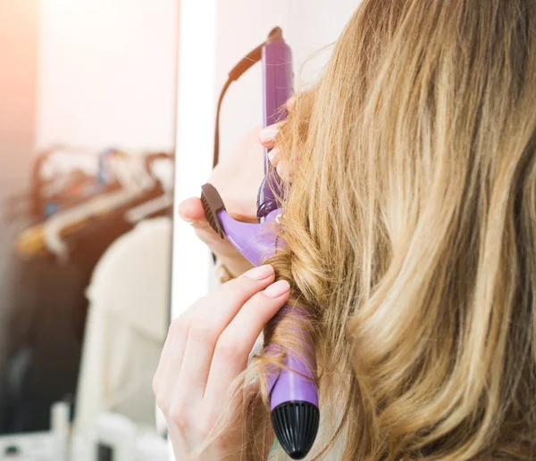 Frisør curling blonde kvinde hår med elektrisk jern curler tong - Stock-foto