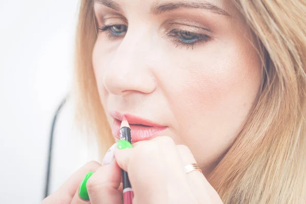 Foto af stylist holde blyant læbe, mens farve klient læber - Stock-foto