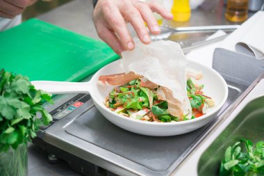 Bir İtalyan şef taze sebze, lezzetli ve sağlıklı gıda ile bir restoranda bir salata hazırlar