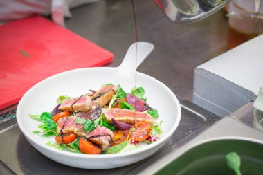 şef domates ve sebze, ızgara balık ile taze bir salata hazırlar