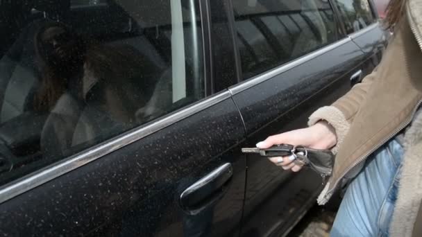 Dłonie kobiety otwierają drzwi samochodu z bliska, wsiadają do samochodu i zamykają drzwi. — Wideo stockowe