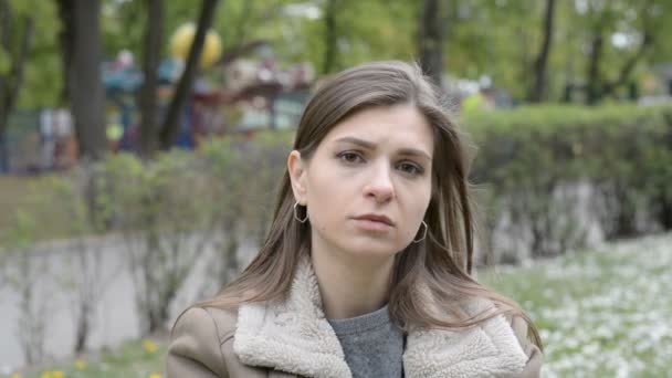 Portret van een mooi jong meisje met een trieste gezichtsuitdrukking — Stockvideo