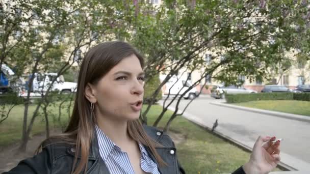 Красивая девушка в парке курит сигарету — стоковое видео