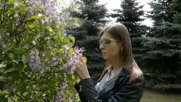 Niña olor a lila árbol florece en el jardín de primavera — Vídeos de Stock