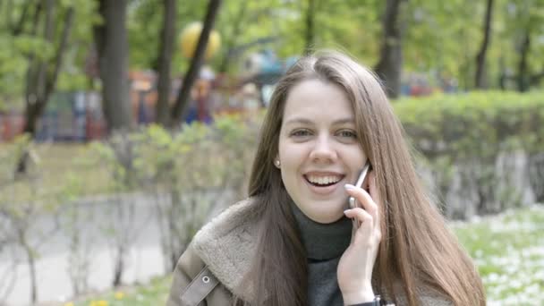 Счастливая девушка красивый портрет разговаривает по мобильному телефону и улыбается — стоковое видео