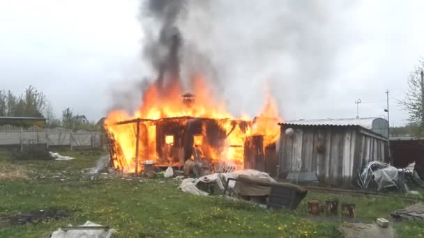 Uma pequena casa de madeira rural onde os pobres vivem está em chamas — Vídeo de Stock