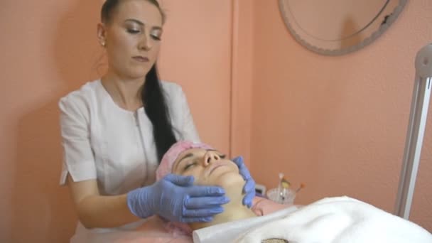 Menina atraente veio ao salão de beleza para fazer procedimentos cosméticos com a pele do rosto, cuidados com a pele para a mulher — Vídeo de Stock