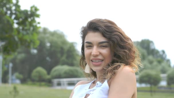 Gros plan portrait de Femme aux cheveux bouclés regardant la caméra — Video