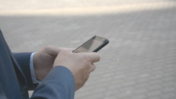 Dokunmatik ekran teknolojisini kullanarak arkadaşlarınızla sohbet etmek için akıllı telefonu tutan adamın ellerinin yakın çekim görünümü — Stok video