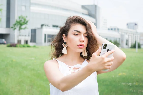 Молода жінка спілкується онлайн в парку — стокове фото