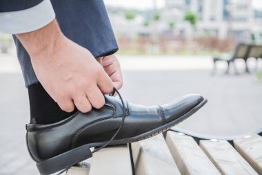 Eller erkek, damat, işadamı onun yeni siyah deri iş ayakkabıları bağcıkları bağlama, yakın çekim.